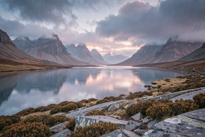 Paysage brumeux des Highlands écossais au lever du jour avec un loch glaciaire reflétant les montagnes et la bruyère dorée