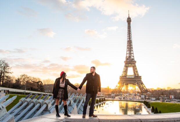 Shot of the happy couple taking pictures with Eiffel Tower on the background, Paris, France