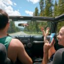 Young woman with instant camera driving on road trip with boyfriend, Breckenridge, Colorado, USA